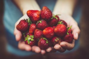 Person holding strawberries in their hand