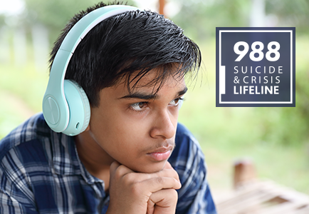 young boy listening to headphones staring out